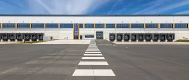 Asphaltierte Fläche vor einer Logistikhalle.