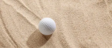 Golfball auf Sand.