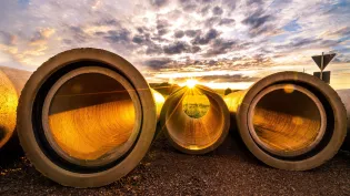 Drei Betonrohre auf dem Boden mit Abendsonne.