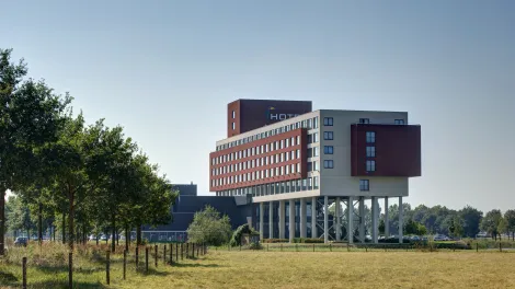 Hotelgebäude mit einer wiese und Bäumen im Vordergrund