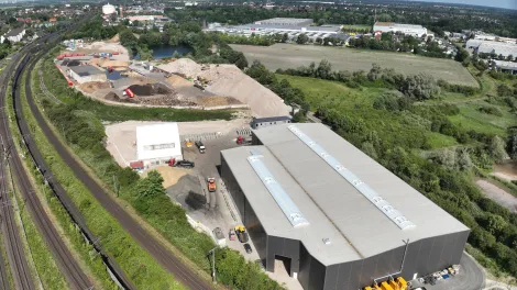 Luftaufnahme einer Halle und recycelter Baustoffe.