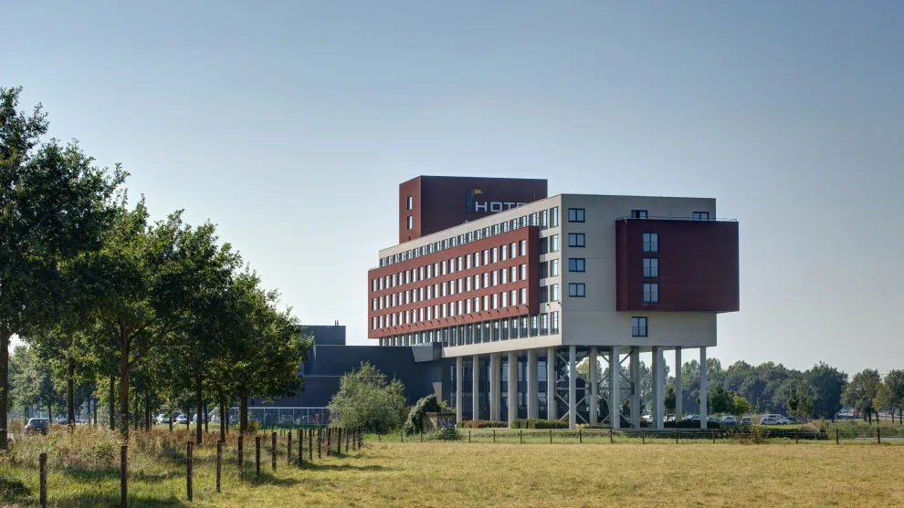 Hotelgebäude mit einer wiese und Bäumen im Vordergrund