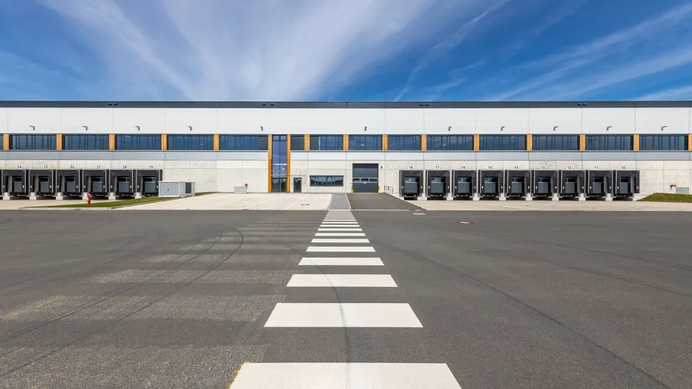 Asphaltierte Fläche vor einer Logistikhalle.