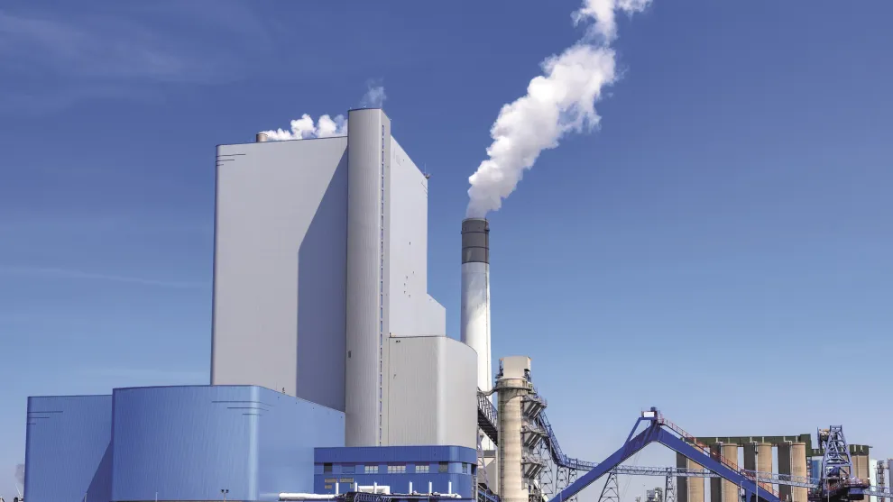 Fabrik mit rauchendem Schornstein.