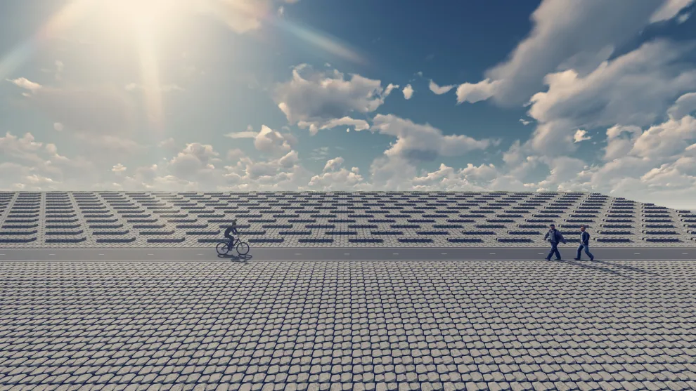 Deich aus basalton-Küstenschutz mit blauem Himmel, zwei Fußgängern und einem Radfahrer.