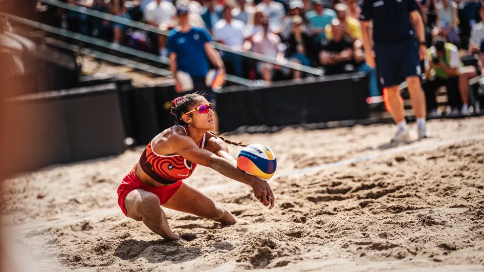 Beachvolleyballspielerin nimmt einen Ball an.