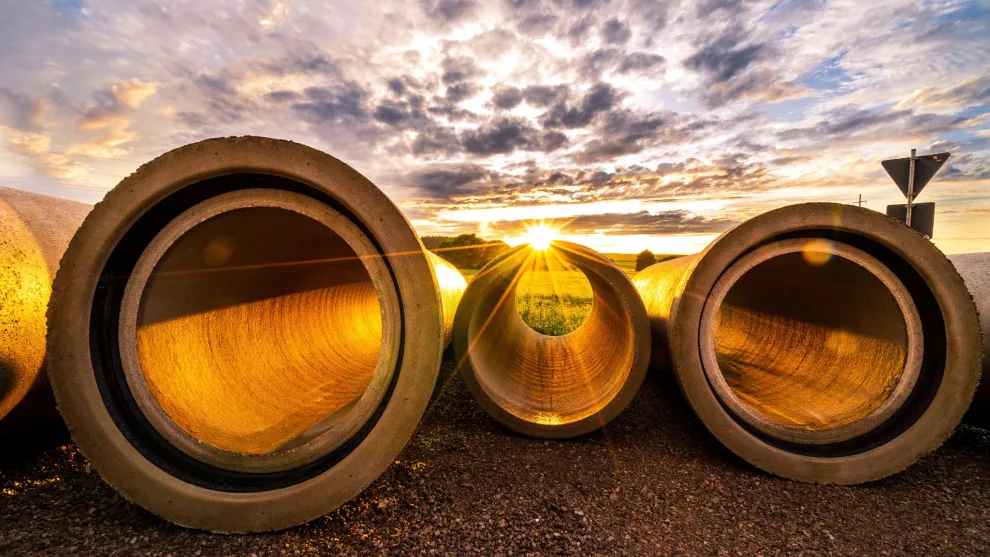 Drei Betonrohre auf dem Boden mit Abendsonne.