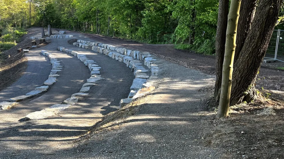 Stufige Landschaftsgestaltung mit Senk- und Mauersteinen und Bäumen.
