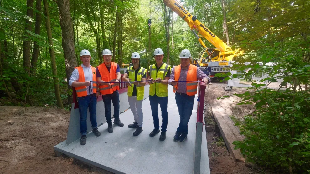 cpc Modulbruecke in einem Wald mit Menschen und Kran im Hintergrund.