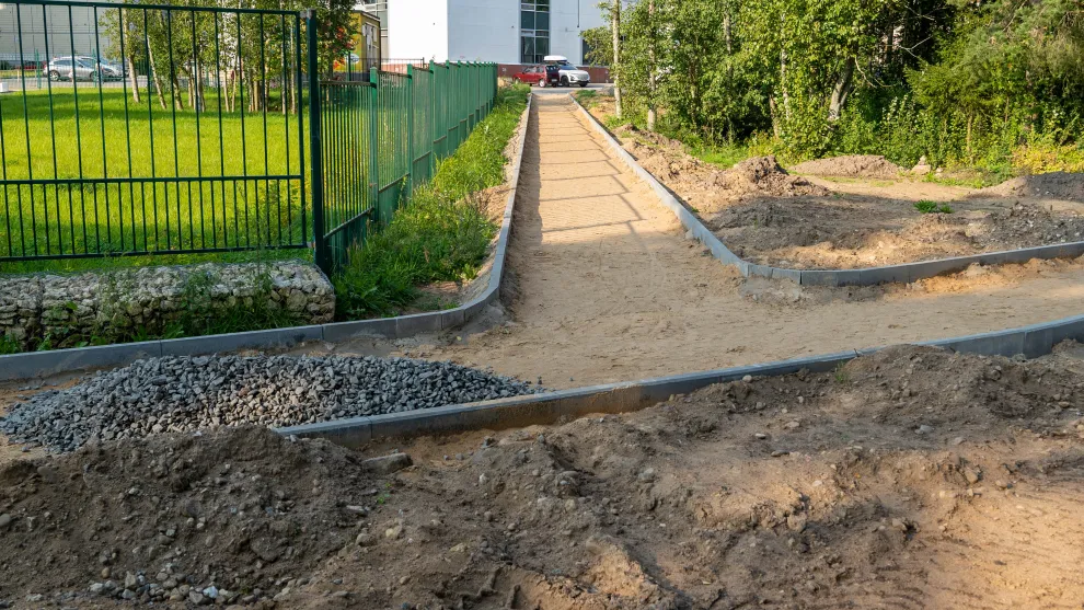 Fußweg in Arbeit - Wegbegrenzung aus Beton mit Sand und Splitt.