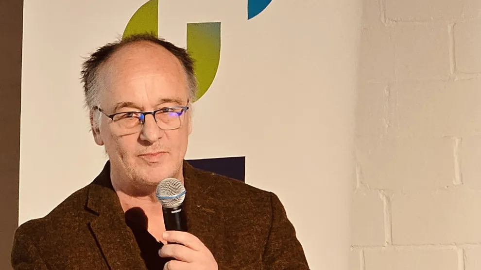 Prof. Wallmann mit einem Mikrofon in der Hand