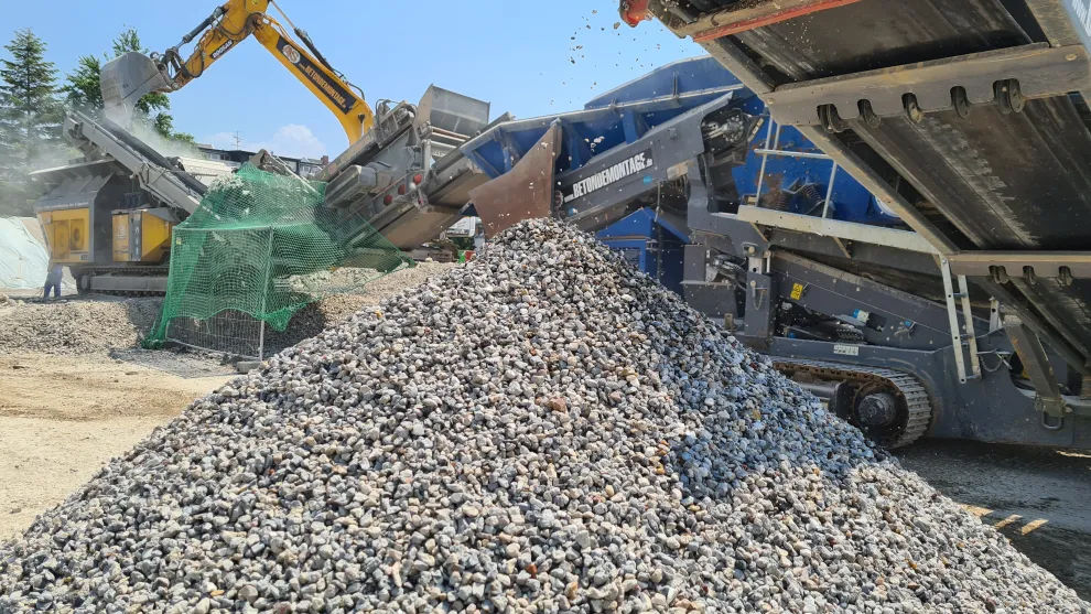 Kieshügel mit Bagger und Förderband.