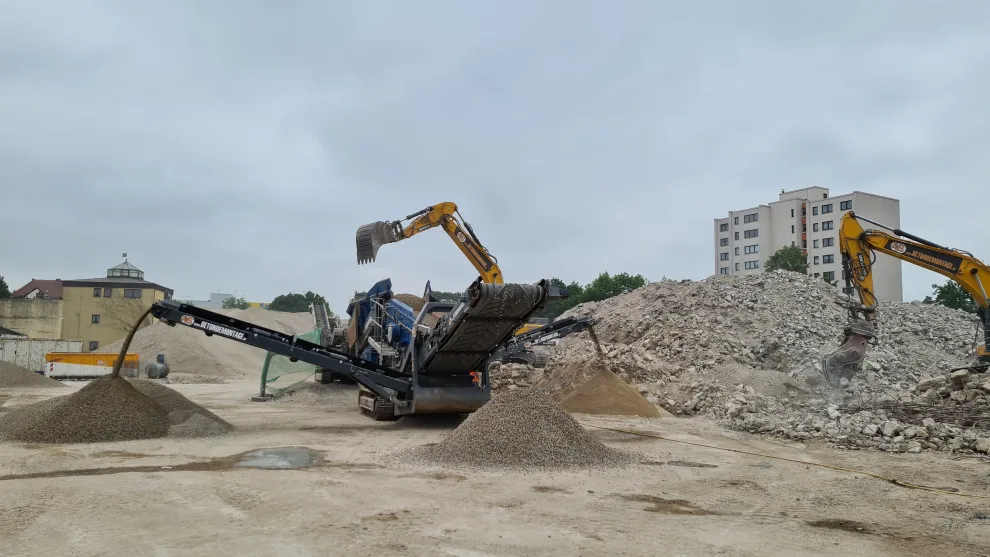 Hügel aus recycelten Baustoffen mit Laufband und Baggern.