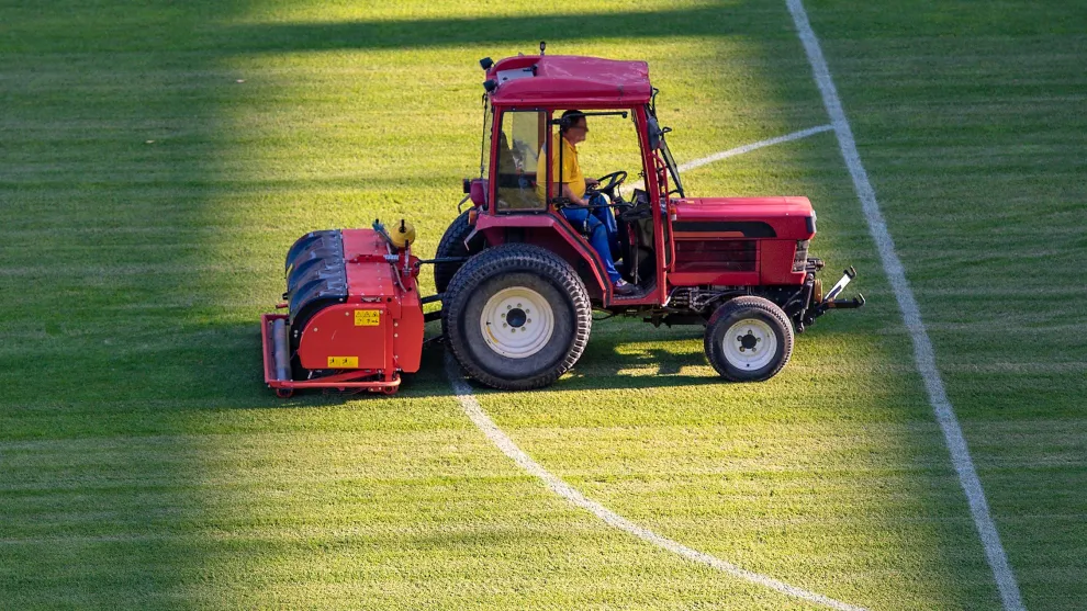 Pflege-Fahrzeug auf einem Rasensportplatz.