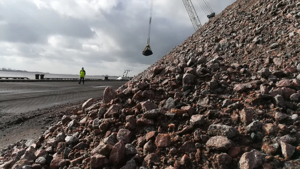 Berg aus Glensanda Gesteinskörnung im Terminal mit einem Kran im Hintergrund.