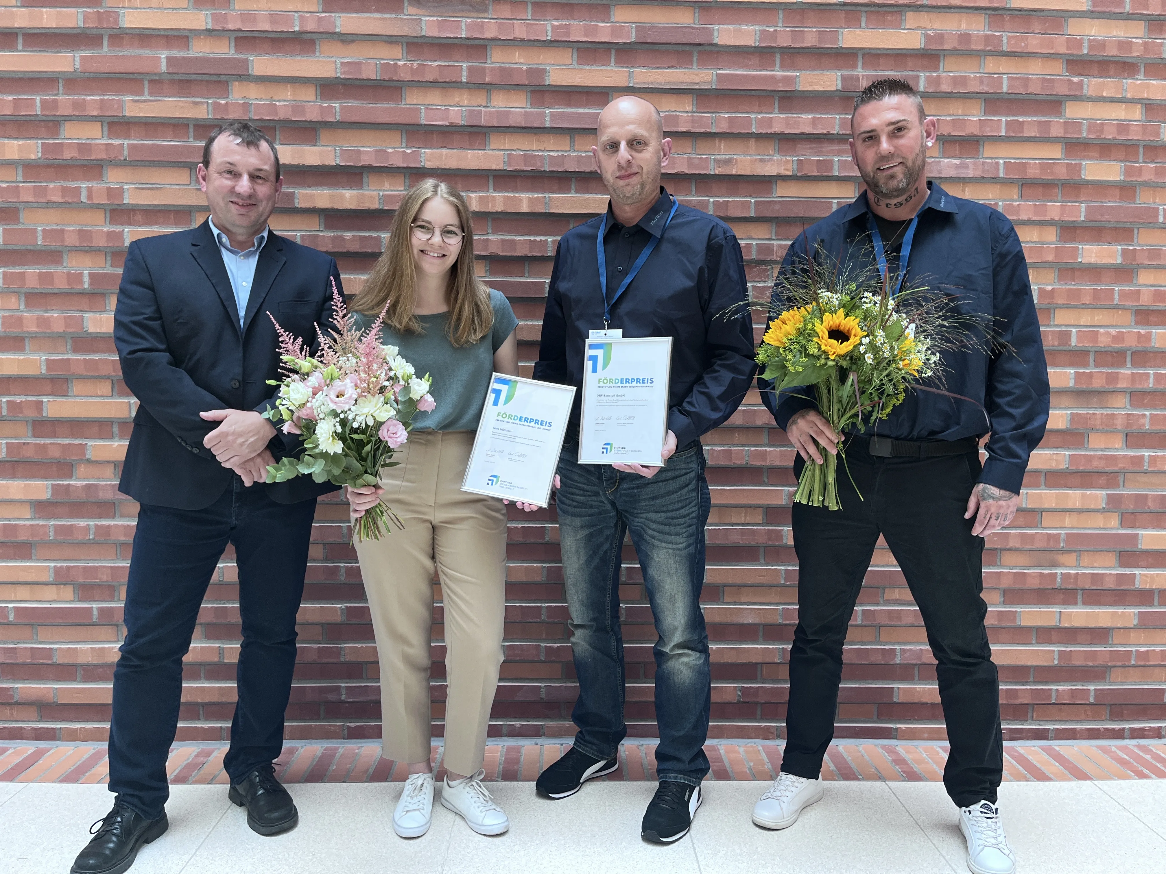Die Preisträger des SEBU-Preises 2025 mit Blumen und Urkunden.