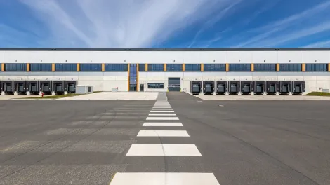 Asphaltierte Fläche vor einer Logistikhalle.