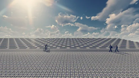 Deich aus basalton-Küstenschutz mit blauem Himmel, zwei Fußgängern und einem Radfahrer.