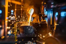 Glühende Flüssigkeit wird in ein Behältnis gegossen. 